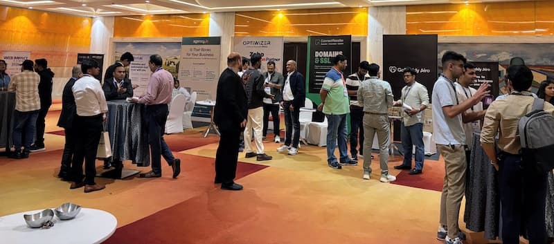Networking at Web Impact Summit 2026 in front of the agency.in booth